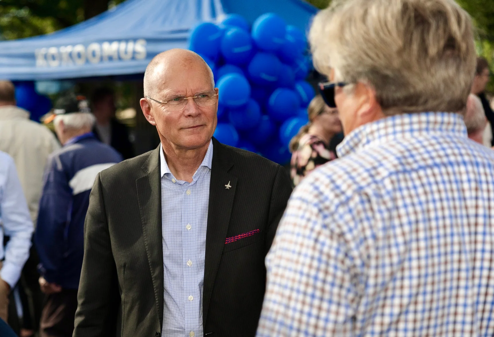 Jarmo Lindberg keskustelemassa äänestäjän kanssa Kokoomuksen vaaliteltan edessä.